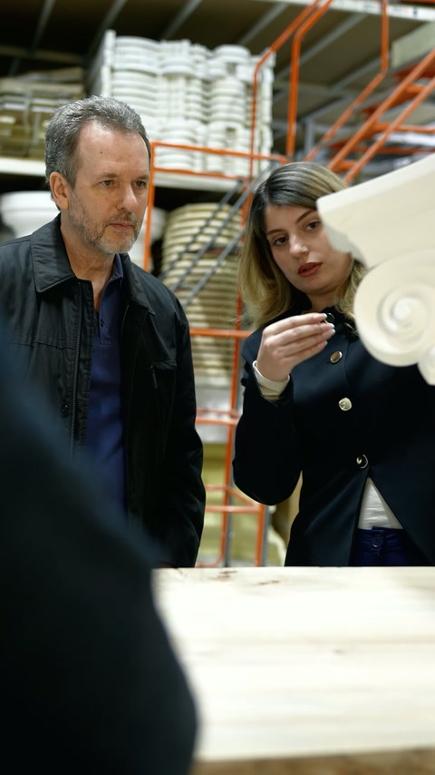 Experts examine white cornice and profile samples in the production area