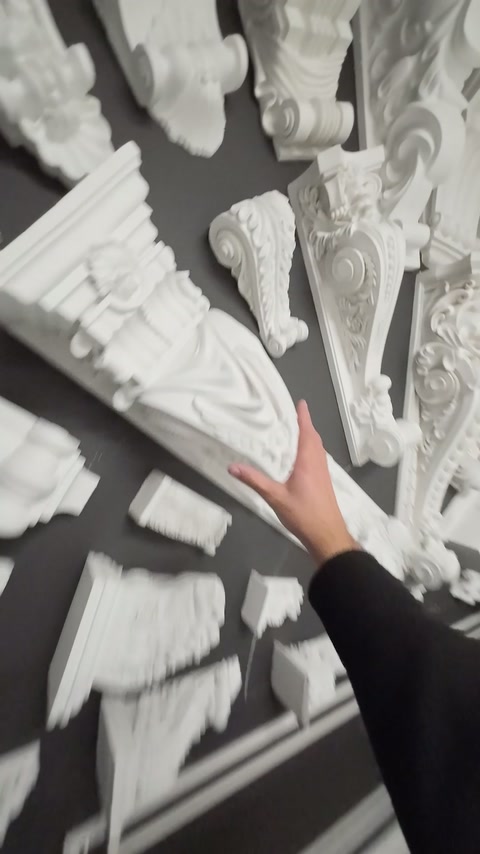White decorative appliqués with different motifs are examined on a panel