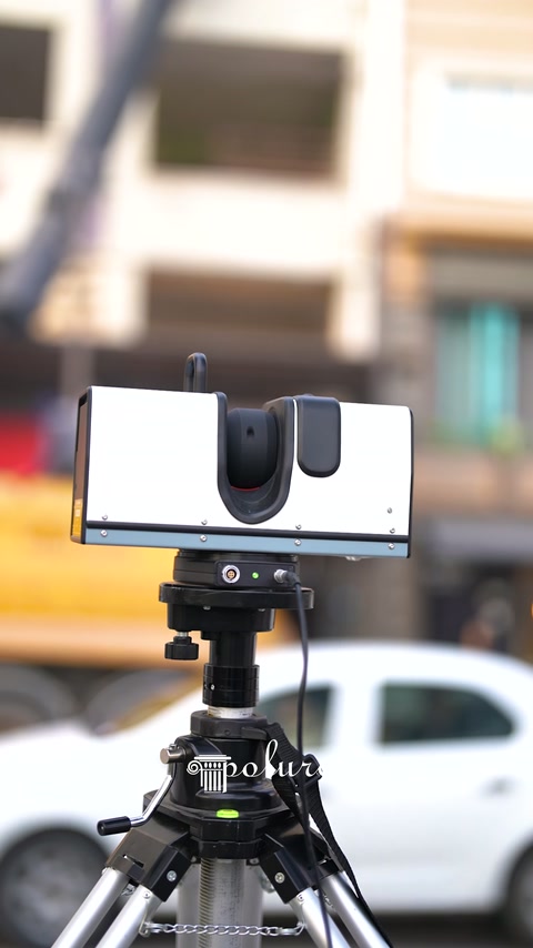 Scanning equipment mounted on tripod directed toward the building facade