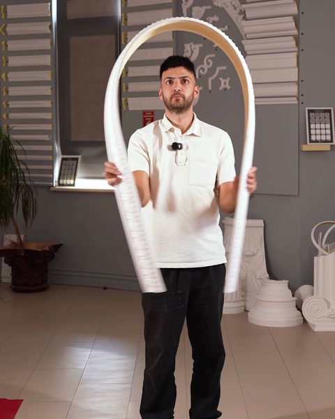 Presenter holds a curved decorative border moulding for showroom demonstration