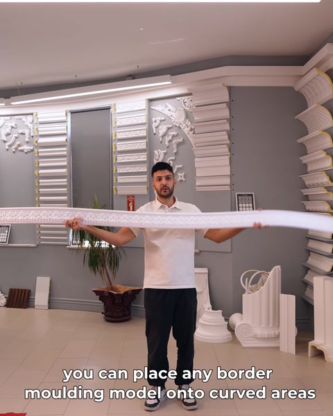 A long flexible moulding is bent by hand beside the display