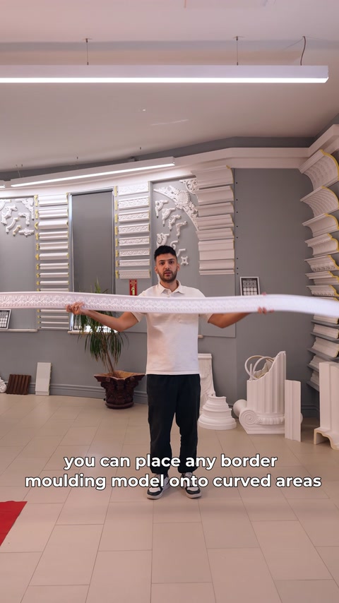 A long flexible moulding is bent by hand beside the display