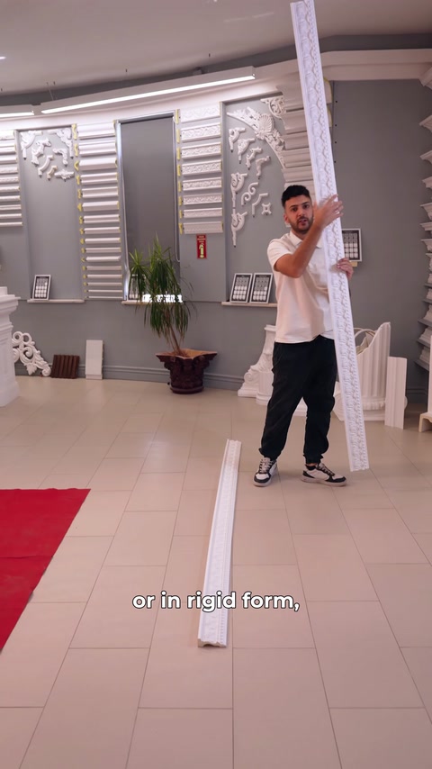 Presenter holds a straight rigid moulding upright in the showroom
