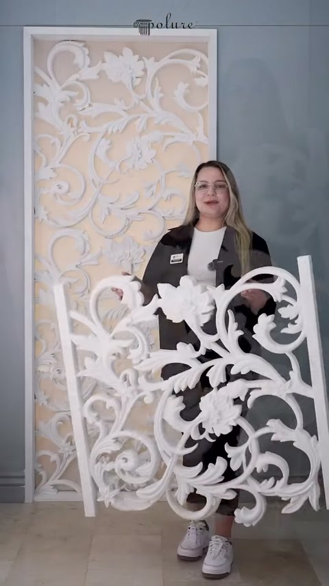 Il presentatore tiene il pannello decorativo con disegno botanico bianco nell'area espositiva