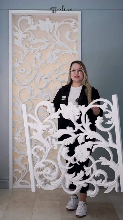 Il pannello traforato bianco con motivi di fiori e foglie viene presentato frontalmente
