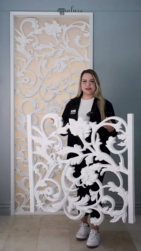 Il pannello decorativo bianco viene mostrato davanti a un modello simile sulla parete