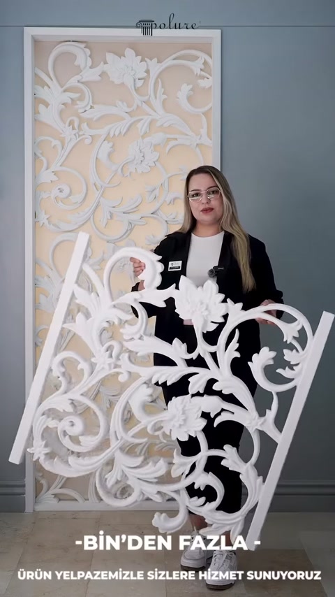 Il presentatore inclina leggermente il pannello bianco con fiori per mostrare i disegni