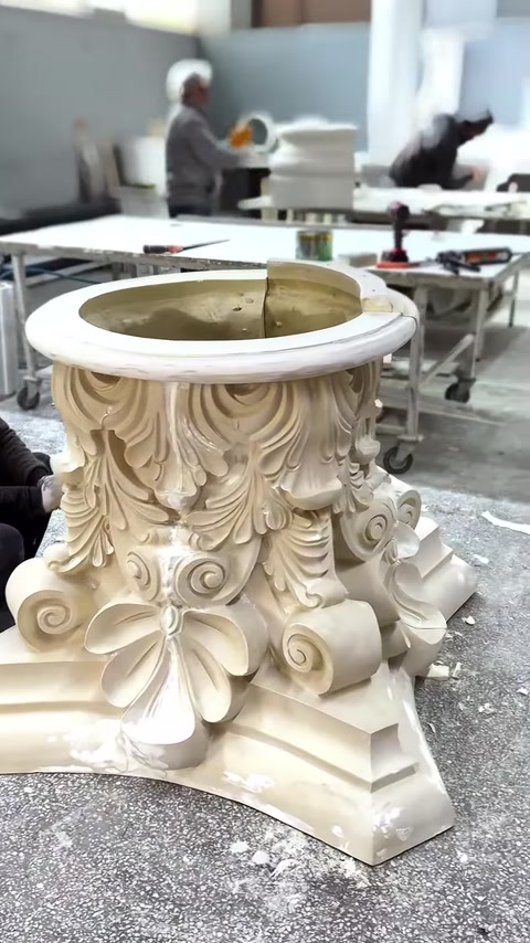 Primo piano di un grande capitello corinzio con foglie intagliate e volute dettagliate.