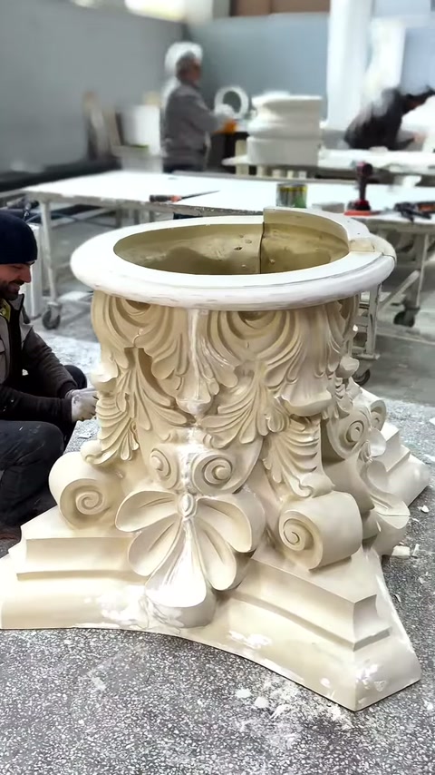 Capitello di colonna con motivi a foglia stratificata è esaminato nell'area di produzione.