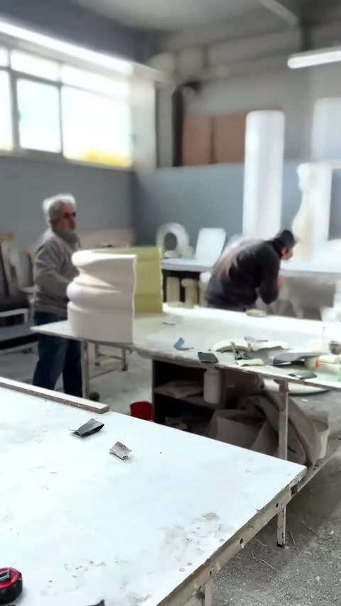 I maestri elaborano elementi decorativi davanti agli attrezzi manuali sul banco.