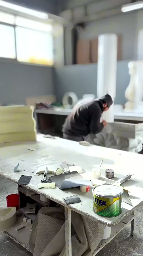 Il maestro accanto al capitello corinzio organizza le parti sul piano di lavoro.