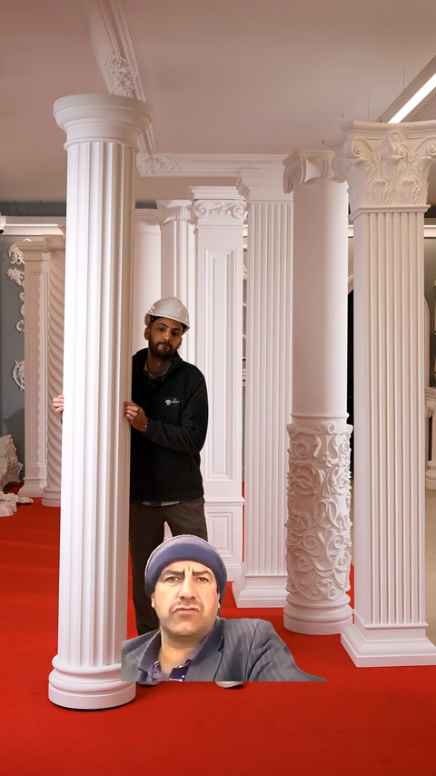 Tall column with capital displayed next to an attendant, showing the detailed fluted body.