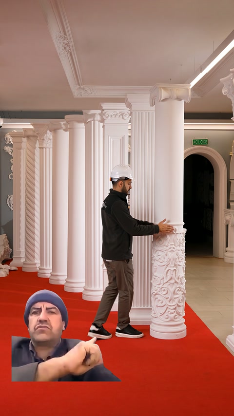 Plain shaft column is examined by hand next to its ornamental lower section.
