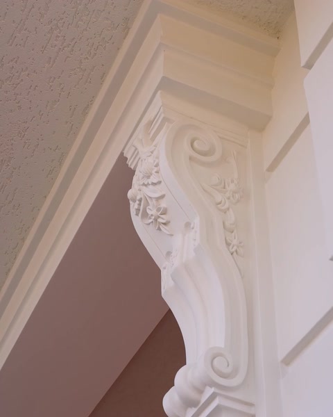 Primo piano di una mensola decorativa che sostiene l'angolo di un architrave curvo