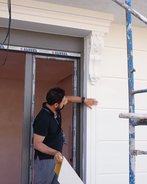 Operaio che testa a mano la durabilità di una modanatura di finestra installata