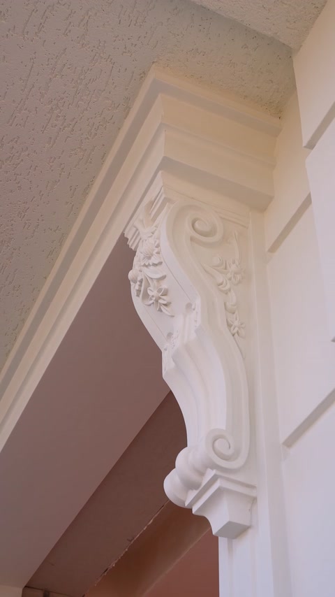Close-up of decorative bracket supporting a curved architrave corner