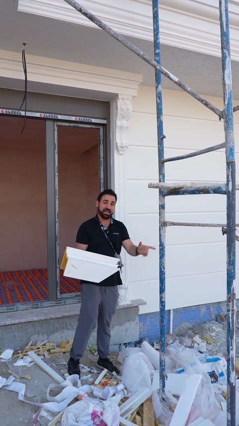 Man carrying molding piece near window during installation
