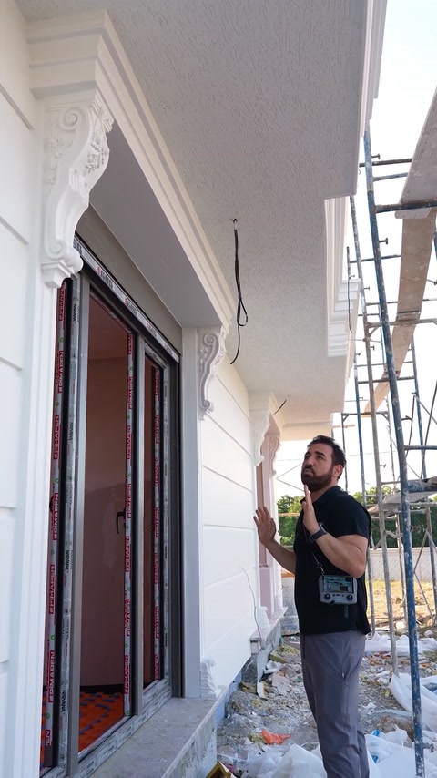 Worker reaching up to install bracket detail at column top