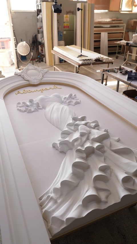 The wedding dress relief and floral ornaments are positioned within the curved frame.