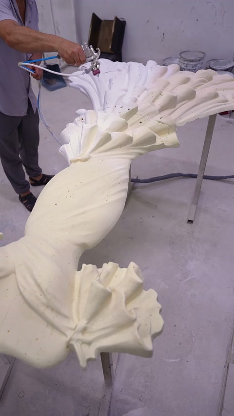Upper section of decorative ornamental relief is coated with spray gun at workshop.