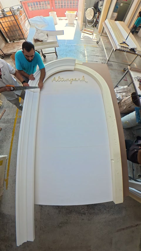 Curved frame profiles are joined around text-inscribed white panel.