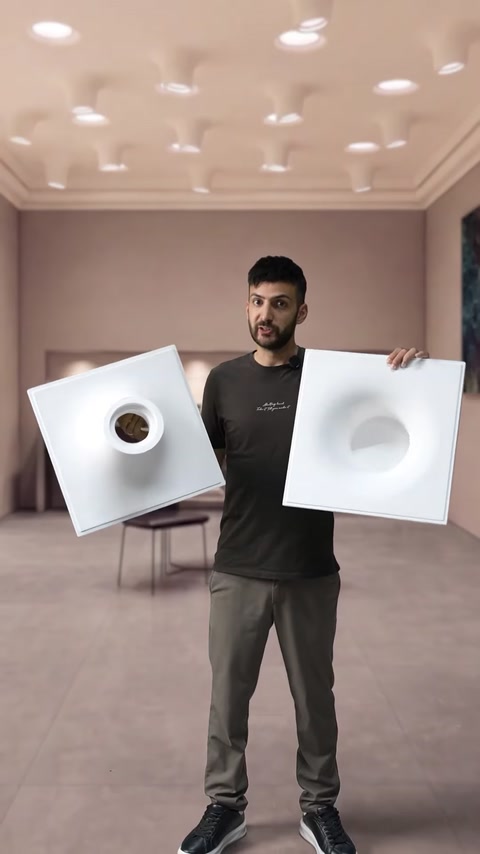 Il presentatore confronta due pannelli quadrati con forme luminose scultoree incassate
