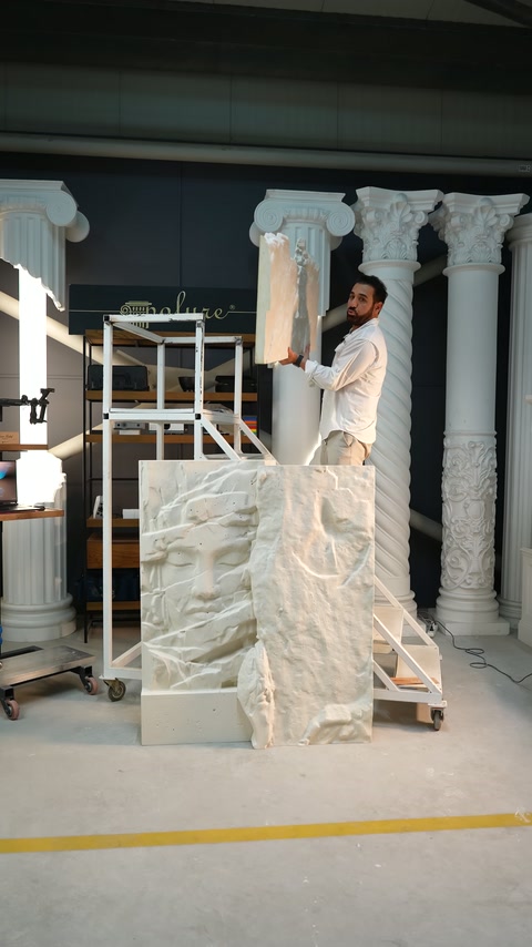 Presenter carries the relief panel to be placed in the upper row onto the platform.