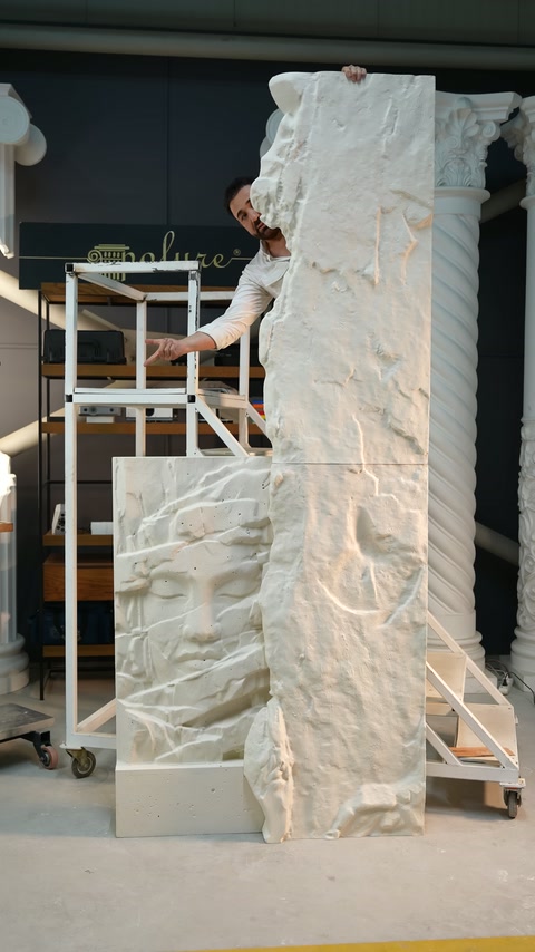 Presenter points out the surface transitions beside the tall relief arrangement.