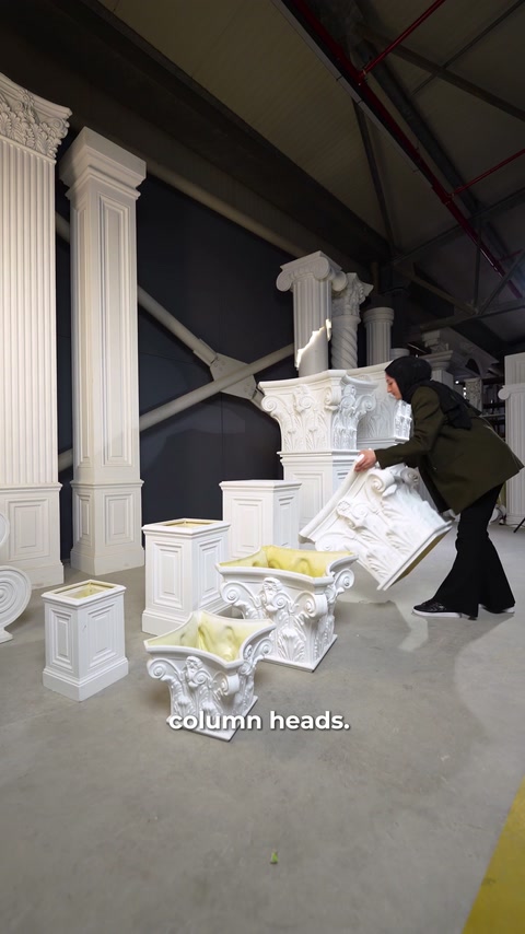 Un operaio scarta un capitello imballato prima di collocarlo in esposizione