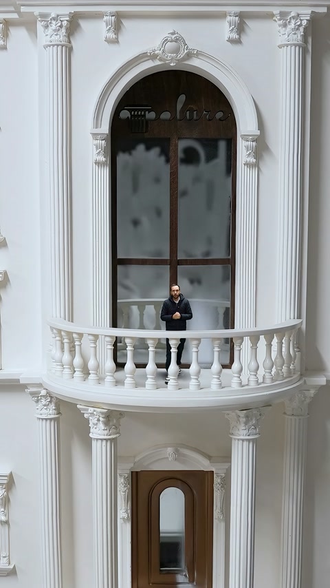 È visibile un modellino di facciata con balcone curvo, balaustre e colonne