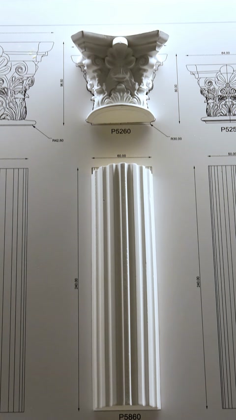 Un fusto di colonna scanalato e un capitello decorato sono esposti con disegni tecnici