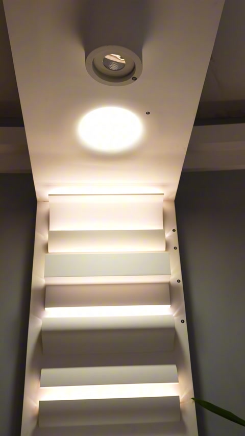 Scala con strisce di illuminazione incassate nella cornice lungo ogni gradino