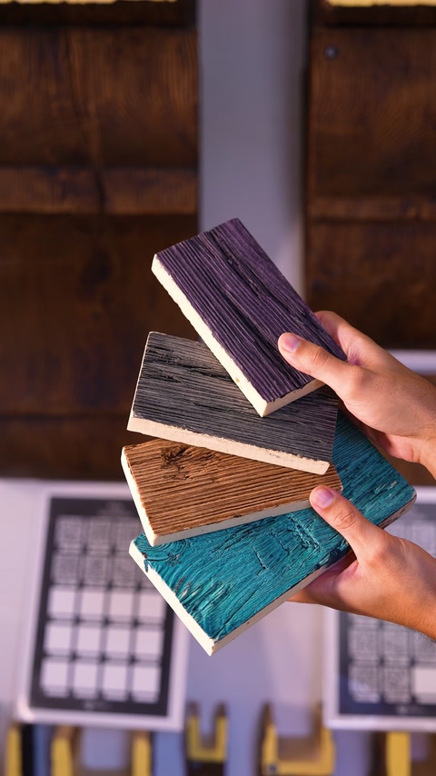 Mano che tiene diversi pannelli campione con texture effetto legno