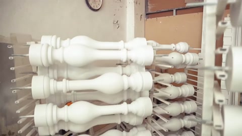 Segmenti di colonne decorative disposti su scaffali visti da vicino.