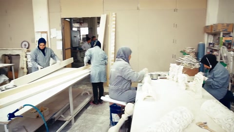 Operazioni di finitura superficiale su prodotti decorativi bianchi in corso al laboratorio.