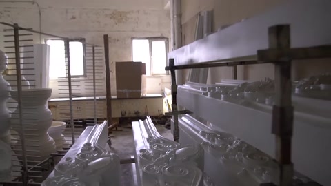 Profili ornamentali di varie dimensioni esposti su scaffali.