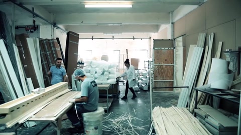 Area di produzione che mostra profili e operai insieme nella struttura spaziosa.