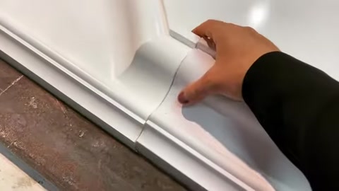 A craftsman inspects the profile details of a manufactured window surround.