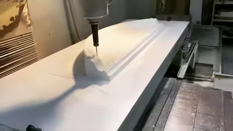 A CNC machine cuts a curved surround form on the polyurethane sheet.