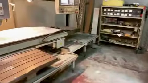 Un grande elemento modello bianco è posizionato per la lavorazione su una macchina CNC