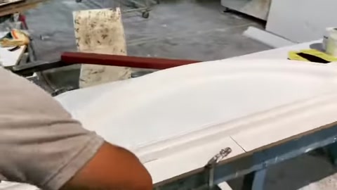 La superficie di un ampio modello di cornice per finestra viene rifinita a mano in laboratorio