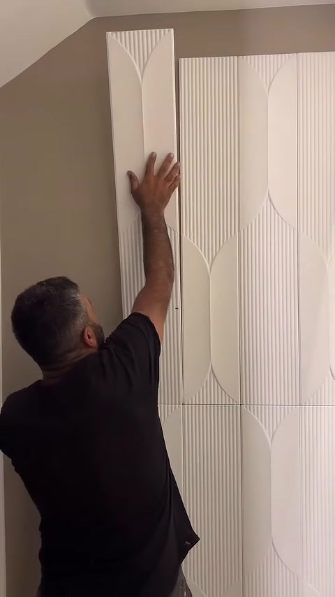 Desenli 3D panel duvar yüzeyinde dikey olarak konumlandırılıyor.