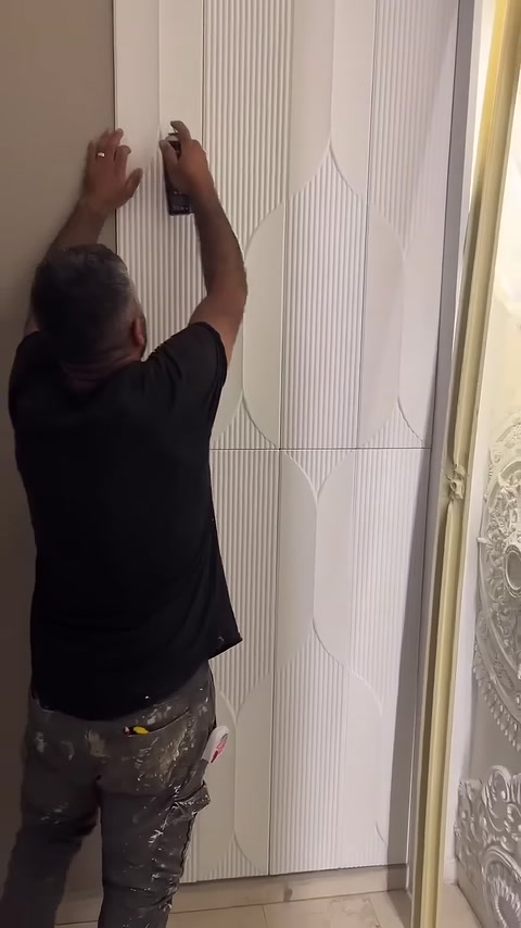 The upper panel edge is secured with adhesive and pressed against the surface.