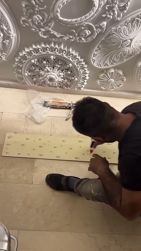 Zemine yatırılan uzun duvar paneline aralıklı yapıştırıcı damlaları bırakılıyor.