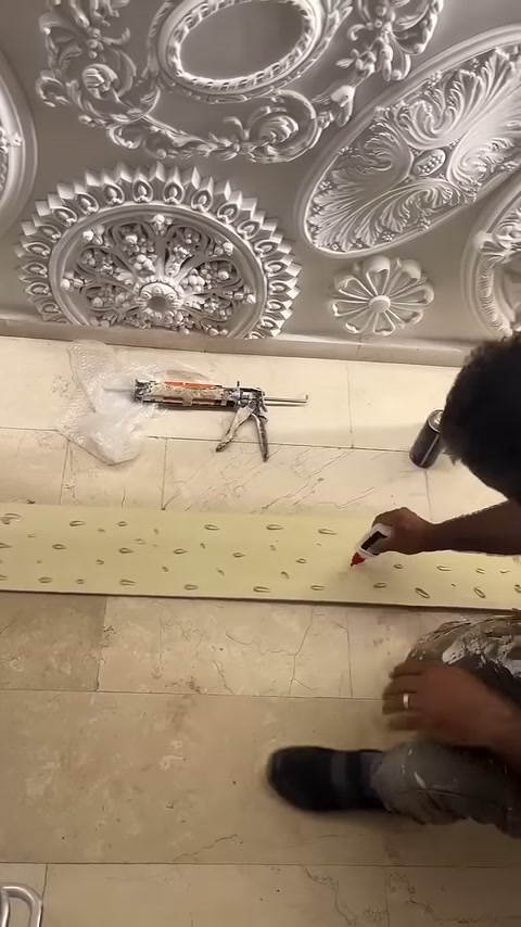 Usta panelin açık renkli arka yüzünde yapıştırma hazırlığını tamamlıyor.
