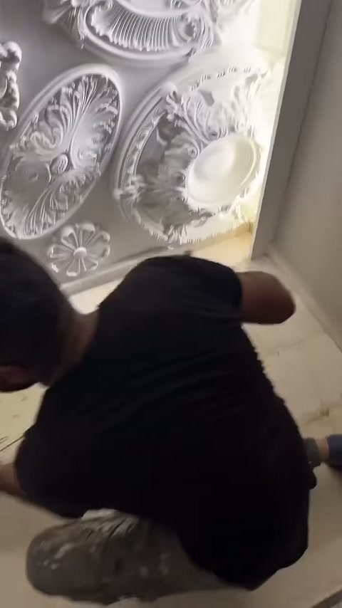 Usta hazırlanan uzun paneli duvara taşımak üzere kavrıyor.
