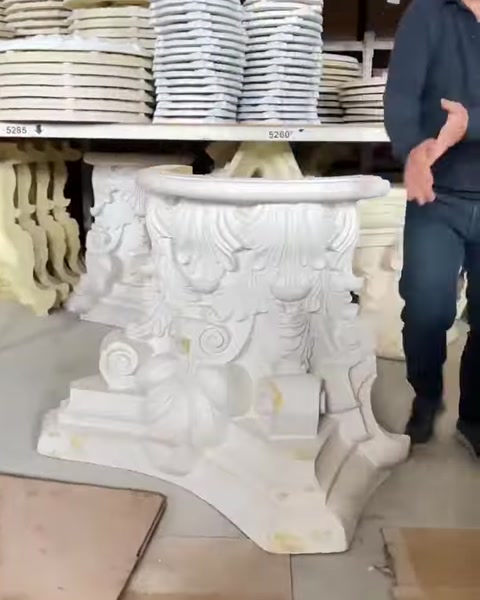 Ornate decorative capitals and carved architectural details sit on shelves