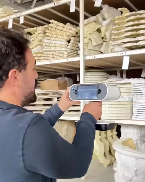 Operator scans a large carved architectural element in the warehouse