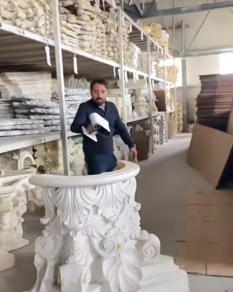 Worker presents a richly detailed decorative column capital