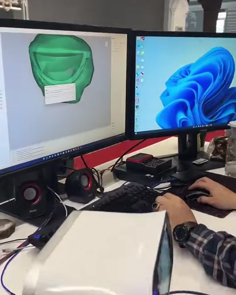 Computer monitor displays a green scanned surface alongside digital modeling